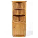 An Ercol blonde elm and beech wood free standing corner cabinet,
