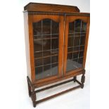 A late Victorian mahogany display cabinet bookcase, projecting cornice over two arched glazed doors,
