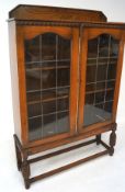 A late Victorian mahogany display cabinet bookcase, projecting cornice over two arched glazed doors,