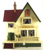 A vintage doll's house, with later signs for the Snooty Fox Pub,