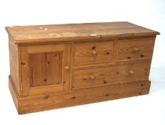 A modern pine low chest, with three drawers in two sizes and a cupboard, L105cm x D41.