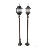 Two contemporary metal garden lanterns on stands, with prism cut shades and on hexagonal base, 135.