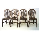 Four 20th century stained pine wheelback chairs, on tapered supports,