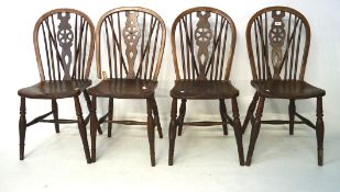 Four 20th century stained pine wheelback chairs, on tapered supports,