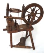 A contemporary spinning wheel, constructed of mahogany, on tripod support,