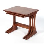 A 1970's teak nest of three tables with shaped supports united by a stretcher,