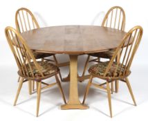 An Ercol blonde elm and beech wood drop leaf dining table and a set of four hooped spindle back