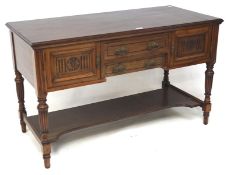 An Edwardian mahogany side table, with two central drawers flanked by cupboards,