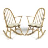 Two Ercol blonde elm elbow rocking chairs with padded seats,