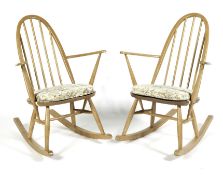 Two Ercol blonde elm elbow rocking chairs with padded seats,