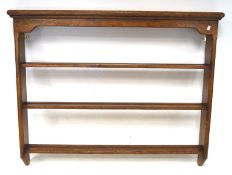 A oak wall mounted plate rack, with three fixed shelves,