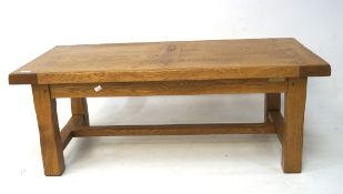 A contemporary oak coffee table, on square supports with a stretcher,