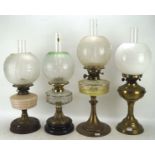 Four Victorian and later oil lamps, with metal, glass and ceramic reservoirs and bases,