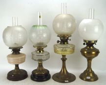 Four Victorian and later oil lamps, with metal, glass and ceramic reservoirs and bases,