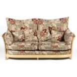 An Ercol blonde beech elm upholstered sofa, with removable cushions of large proportions,
