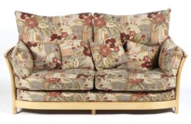 An Ercol blonde beech elm upholstered sofa, with removable cushions of large proportions,