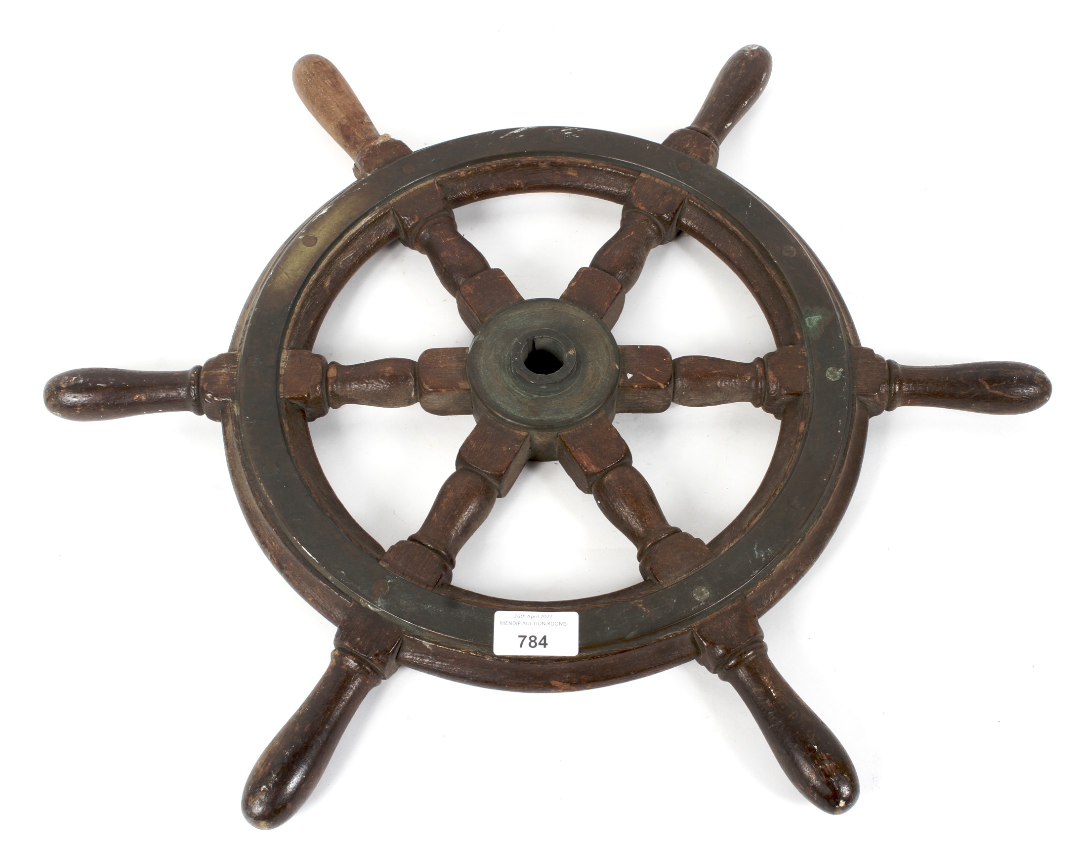 A vintage wooden metal-mounted six-spoke ships wheel,