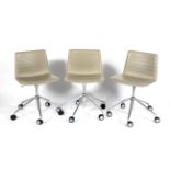 A set of three Andreu World (National Design Award Company 2007) faux leather swivel chairs raised