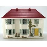A vintage Tri-ang style doll's house, with red plastic roof and sliding metal front,