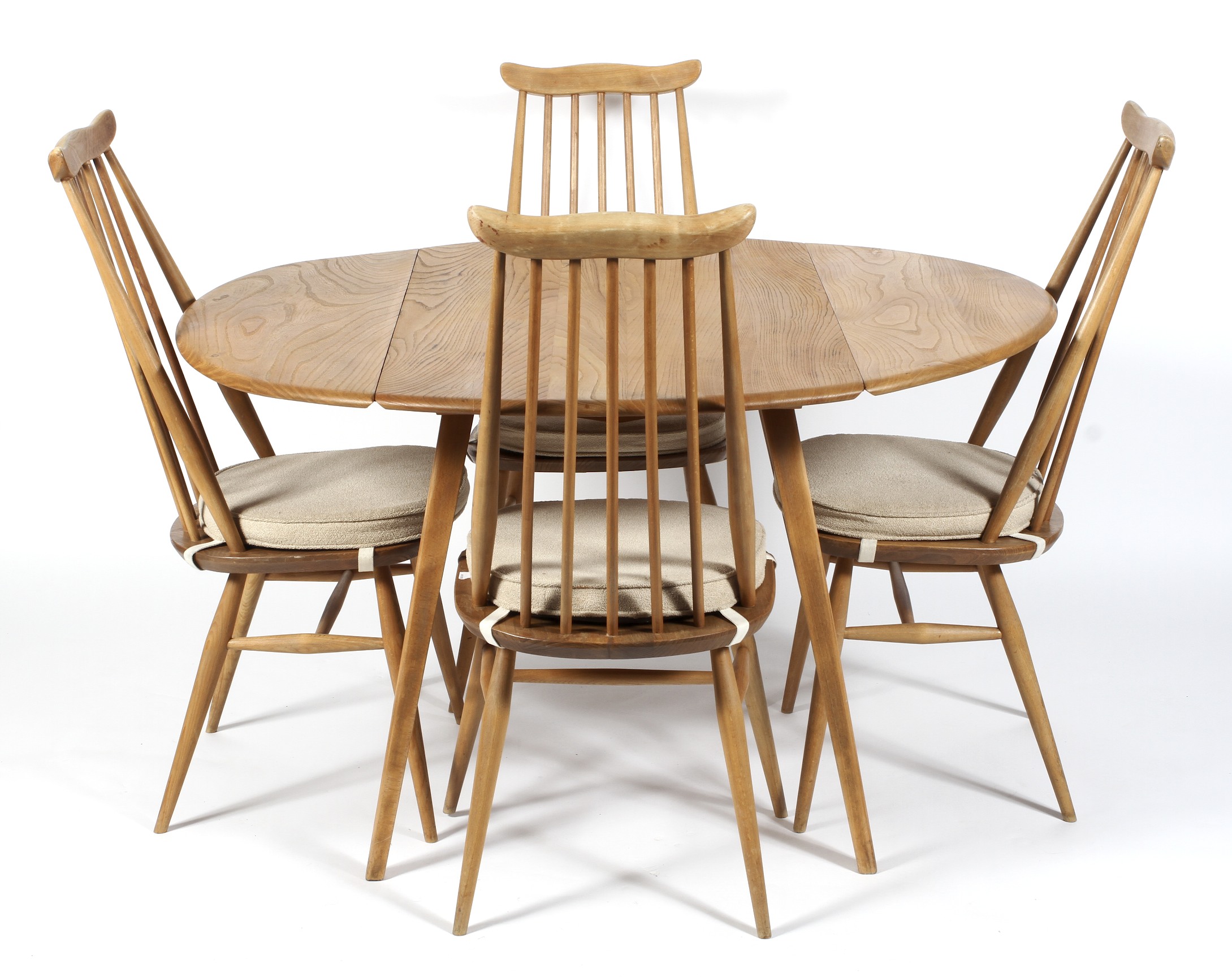 An Ercol dining room suite comprising a drop leaf table and four high spindle back dining chairs,