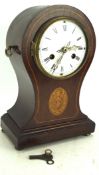 An inlaid mahogany clock, the white enamel dial with Roman numerals, on bun feet,