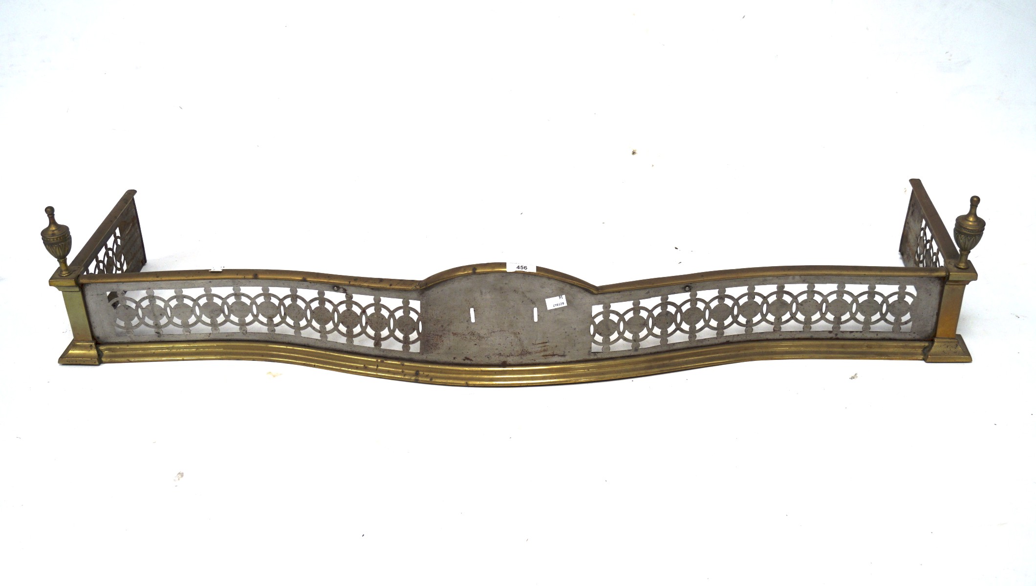 A early 20th century brass and steel fender, of curved form with pierced details,