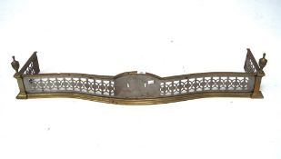 A early 20th century brass and steel fender, of curved form with pierced details,