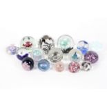 Sixteen paperweights, with flower, millefiori and bubble inclusions predominately in blue,