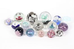 Sixteen paperweights, with flower, millefiori and bubble inclusions predominately in blue,