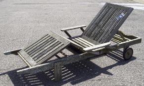An adjustable slatted wooden sun lounger, on wheels,