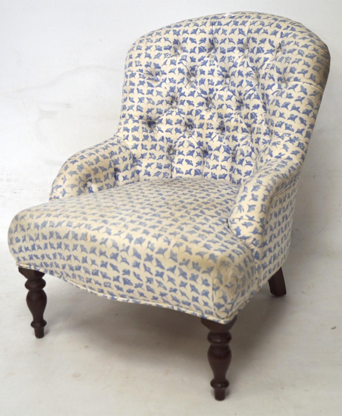 A button back nursing chair on turned front supports, with white and blue cotton upholstery,