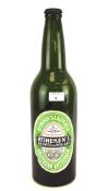 A large vintage empty green glass Heineken bottle, with cap,