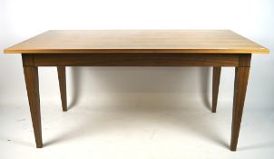 A contemporary wooden veneered dining table, of rectangular form, on tapered square supports,