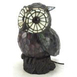 A Tiffany style owl shaped table lamp, perched on rocky metal base, electrified,