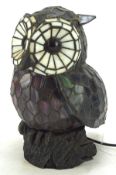 A Tiffany style owl shaped table lamp, perched on rocky metal base, electrified,