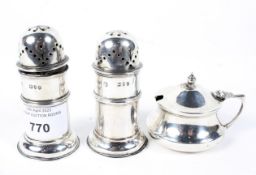 Three silver condiments, a pair of salt and pepper shakers, marked London, 1895,