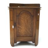 An Edwardian corner wall cabinet, featuring a panel front decorated with inlay,