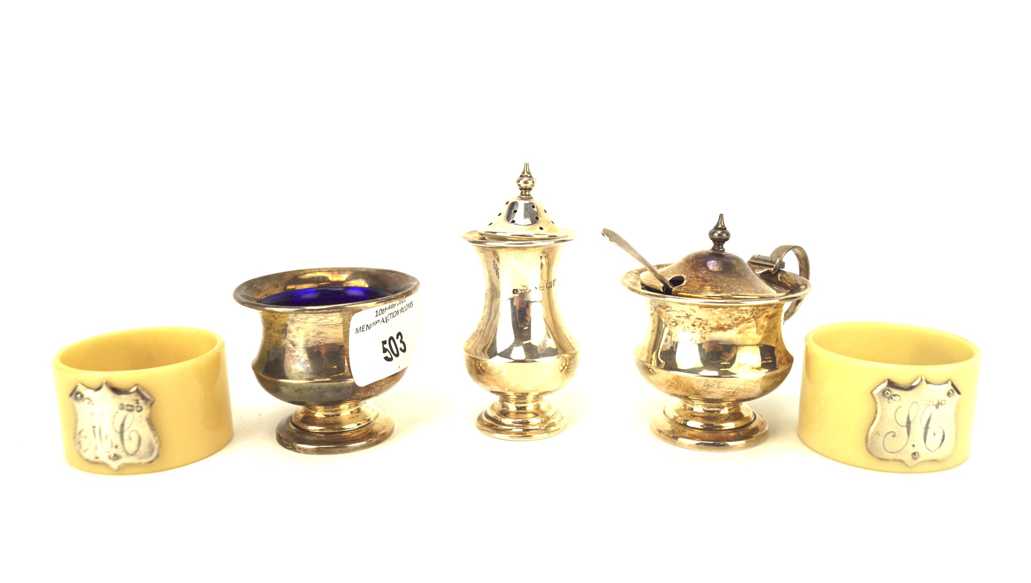 A George V three piece silver condiment set and a pair of napkin rings,