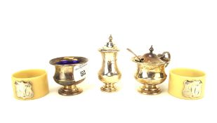 A George V three piece silver condiment set and a pair of napkin rings,