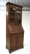 An early 20th century oak bureau bookcase with glazed double doors to the top, with bureau fall,
