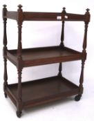 A late 19th/early 20th century mahogany serving trolley, three tiered, with turned supports,