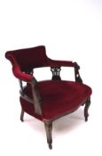 A late 19th/early 20th century mahogany framed armchair, upholstered in red velvet,