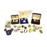 A collection of ceramic brooches, mostly modelled as flowers,