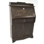 An early 20th century cased desk, heavily carved,
