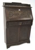 An early 20th century cased desk, heavily carved,