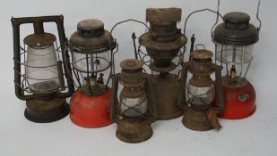 An assortment of six lamps and lanterns, including two hurricane lanterns,