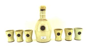 A seven piece Kentmere pottery wine set, comprising single handled wine pourer and six cups,