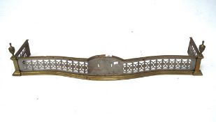 An early 20th century brass and steel fender, of curved form with pierced details,