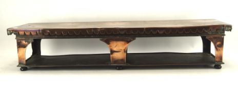 A large late 19th, early 20th century copper plate-warming stand, raised upon bun feet,