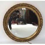 A 20th century bevelled edge wall mirror, of circular form with a gilt frame,